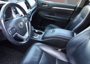 Close-up of 2015 Toyota Highlander XLE interior with leather seats and modern dashboard.